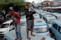 Hundreds of angkot (public minivan) drivers protest on Monday, February 12 by parking their vehicles on the streets of Tebet, South Jakarta. The drivers demanded the Jakarta administration reduce the number of Transjakarta buses serving the Kampung Melayu-Tanah Abang route, as they have led to a reduction of income for the drivers. JP/Wendra Ajistyatama