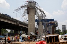 In ruins: Workers clean the rubble scaffolding that supported a pier shaft for the Bekasi-Cawang-Kampung Melayu (Becakayu) toll road in Kebon Nanas, East Jakarta, on Tuesday, February 20. JP/Wendra Ajistyatama