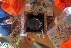 Two women create batik using heated wax. JP/Endro Prakoso