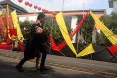 A man carries a female dancer who fainted while performing. JP/Maksum Nur Fauzan