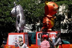 A dancer dressed in a Hanoman costume (left, below) performs accompanied by colleagues dressed as beasts. JP/Maksum Nur Fauzan