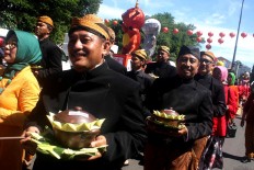 Civil servants wearing traditional Javanese attire carry 17 bowls of jenang (sticky rice porridge). [JP/Maksum Nur Fauzan