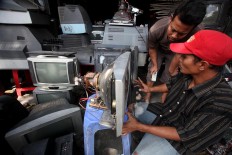 Supriyono (left) and Sugeng discuss how to repair a TV set. JP/Boy T. Harjanto