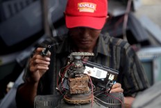 Supriyono is ready to repair a TV set. JP/Boy T. Harjanto