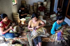 Delicately: A craftswoman weaves the tapuk manggis motifs using bamboo sheets in Tigawasa village. JP/Agung Parameswara