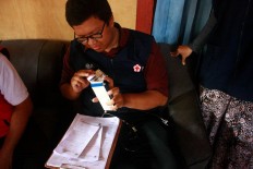 A doctor checks medical supplies. JP/Maksum Nur Fauzan
