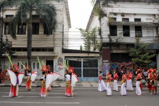 Performers stand in formation and wait their turn to perform. JP/Arya Dipa