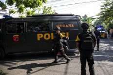 Indonesian policemen patrol outside a church following a suicide bomb in Surabaya on May 13, 2018. At least two people were killed and 13 others injured in bomb attacks, including a suicide blast, targeting churches in Indonesia's second biggest city Surabaya, police said. AFP/ Juni Kriswanto