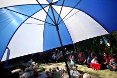 Villagers share food after praying. [JP/Boy T. Harjanto