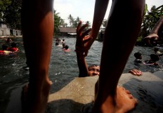 A boy helps his friend to climb up from the pool. JP/Boy T. Harjanto