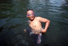 A boy wears goggles as he swims during Padusan. JP/Boy T. Harjanto