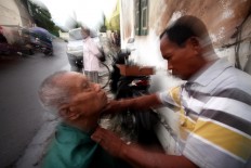 Groom it: Sarjono shaves a customer. JP/ Boy T Harjanto