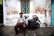 Still surviving: Sarjono has been working as aroving barber since 1984. JP/ Boy T Harjanto