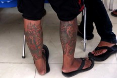 Inked: Numerous patterns and illustrations of tattoos are featured on a man's legs. JP/Maksum Nur Fauzan