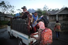 Villagers from Cangkringan district, Sleman regency, Yogyakarta, flee their homes on a pick-up truck on Tuesday, May 22, 2018. JP/Boy T. Harjanto