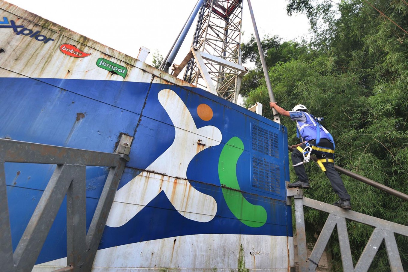 A technician checks a base transceiver station (BTS) near the Tangerang-Merak toll road in Banten on June. 6, 2018.