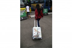 Bon voyage: A woman wheels her luggage before entering a bus at the Kampung Rambutan bus station in East Jakarta. JP/PJ Leo
