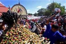 People race to get snacks from the gunungan (cone-shaped offering) during a procession of Grebeg 1 Syawal 1439, a tradition at the Gedhe Mosque in Kauman, Yogyakarta on June 15, 2018. The gunungan symbolizes alms given by the Sultan of Yogyakarta to residents. The kraton made seven gunungan for the residents. JP/Aditya Sagita