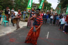 Feel the vibe: A local artist performs a mask dance during the Lebaran Sapi celebration. JP/Maksum Nur Fauzan