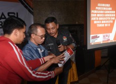General Elections Commission (KPU) staff brief a blind voter on how to cast his vote on a braille ballot paper in Malang, East Java, during a simultaneous regional election familiarization session on Monday, June 25, 2018. JP/Aman Rochman