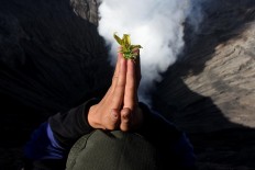 Don't look down: A member of the Tengger tribe prays over the crater of Mount Bromo. JP/ Aman Rochman