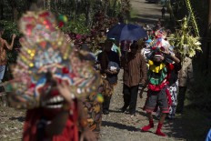 On the way to party: The parade carries kembar mayang (decorated clusters of coconut leaves) symbolizing the groom, Joko Gondel, guarded by three barongan (mythical anonsters to drive away evil spirits), proceeding to the factory. JP/ Sigit Pamungkas