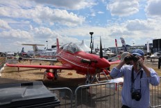 Closer look: A visitor of the Farnborough airshow uses binoculars to check out civilian and military planes. JP/ R. Berto Wedhatama