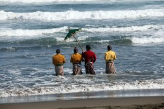 The elders walk into the water as a sign that the ceremony is about to begin. JP/Boy T. Harjanto