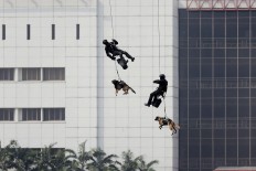Personnel of the Army’s Special Forces (Kopassus), accompanied by sniffer dogs, rappel from a helicopter during a mock terror attack in Jakarta on Wednesday, July 25, 2018. With the involvement of military and police personnel, the training was held by the National Counterterrorism Agency (BNPT) as part of security preparations for the upcoming Asian Games. JP/Dhoni Setiawan