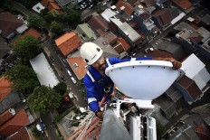 A technician carries out maintenance on a 4G base transceiver station (BTS) in Bendungan Hilir, Central Jakarta, on Friday, July 13, 2018. Publicly listed telecommunications company XL Axiata operates 2,700 4G LTE BTS across Jakarta. JP/ Dhoni Setiawan