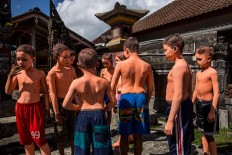 Boys color their bodies before joining the Ngerebeg ritual in Tegalalang village, Gianyar district, Bali. JP/Agung Parameswara