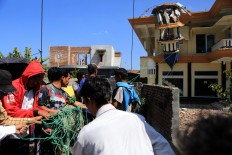 Villagers try to pull a minaret at Al Ihsan Mosque, which was damaged by an earthquake in Batu Layar, West Lombok, on Aug. 8, 2018. JP/Seto Wardhana