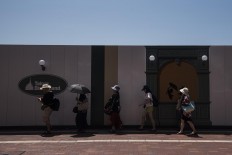 Visitors at Tokyo Disneyland walk in the shade. JP/Rosa Panggabean