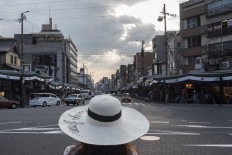 A floppy hat is a must-have accessory for women, in addition to a parasol and a portable fan to deal with the heat. JP/Rosa Panggabean
