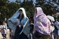 Japanese women use blankets to cover their heads. JP/Rosa Panggabean