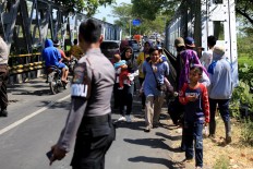 Protector: A police officer keeps order while people flee their homes in Lombok. JP/ Seto Wardhana