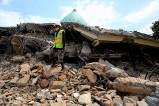 In ruins: A search and rescue officer stands on the rubble of a collapsed building following a series of tremors that have hit Lombok, West Nusa Tenggara, since July 29. JP/ Seto Wardhana