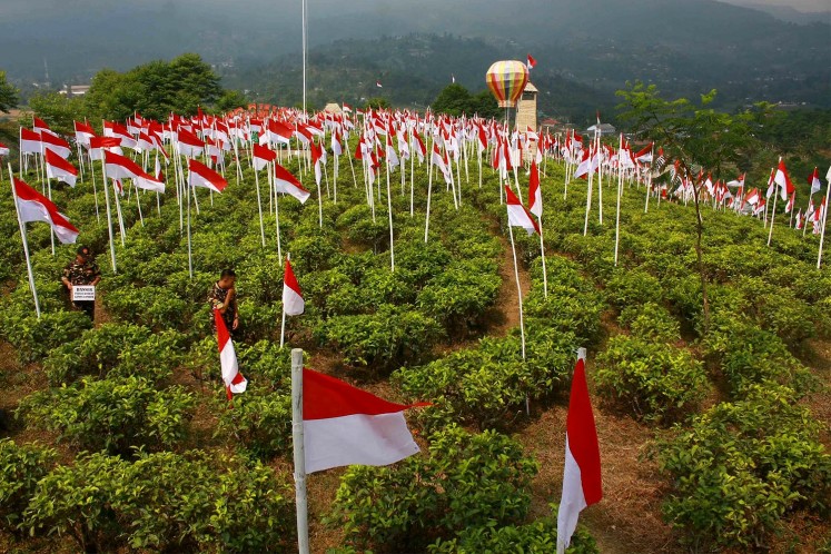 Decorating Mount Cilik with red-and-white flags