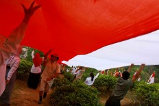 Students and citizens hand-in-hand hoist the giant flag. JP/Maksum Nur Fauzan