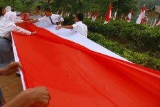 Students prepare to hoist the giant flag of 100 meters long and 3 meters wide. JP/Maksum Nur Fauzan