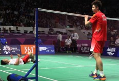 Trough the pain: Indonesia shuttler Anthony Sinisuka Ginting (left) lies on the court after succumbing to an injury during the men's team badminton final against Shi Yuqi from China at the Gelora Bung Karno Sports Complex in Central Jakarta last Wednesday. JP/Seto Wardhana