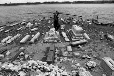 A villager carries his fishing rod, passing graves at the former area of Kenteng village in the Gajah Mungkur dam area. JP/Maksum Nur Fauzan