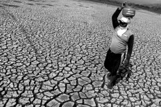 Pedes, a 47-year-old villager, carries a gas canister to help start a pump engine to irrigate the paddy field due to the start of the dry season. JP/Maksum Nur Fauzan