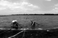 A farmer uses his water pump to pump out water from the dam to his temporary rice field. JP/Maksum Nur Fauzan
