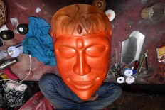Fresh-faced: An orange-painted ondel-ondel face. Craftsmen at the Al-Fathir ondel-ondel workshop use paintbrushes to color their figures. JP/David Caessarre