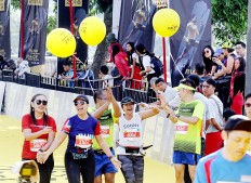 We did it!: Amateur runners cheer upon completing their course in the 2018 Maybank Bali Marathon on Sept. 9 in Gianyar, Bali. Besides earning a medal, these runners also derive satisfaction from knowing that they possess the endurance and determination required to finish the race.