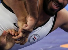 Yemeni wrestler Mohammed Almaghrebi tries to free himself during a match against Kyrgyzstani Ismailov Amantur. JP/Seto Wardhana