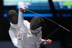 The sword of a Japanese fencer (front) gets tangled with a cable during women's team match against China. JP/PJ Leo