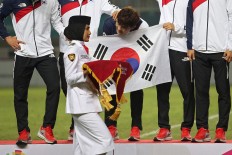 A South Korean footballer teases a woman carrying the medals during a medal ceremony. South Korea's men's soccer team won over Japan's and secured the gold medal. JP/PJ Leo