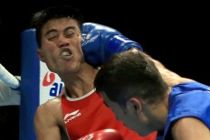 Indonesia's boxer Sunan Agung Amoragam takes a punch from Uzbekistan's Mirzakhalilov Mirazizbek in the men’s boxing bantamweight semifinal. Sunan won the bronze after losing to Mirazizbek. JP/Seto Wardhana.